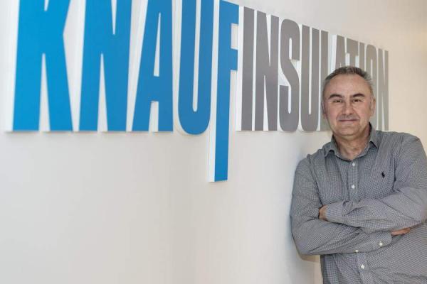 Mark Thompson in front of the Knauf Insulation logo